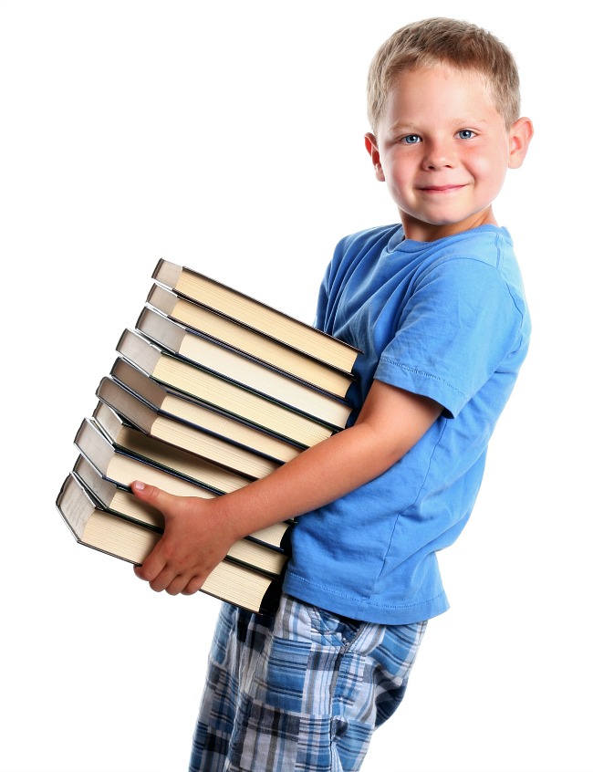 Boy carrying stack of books for heavy work activity at school.