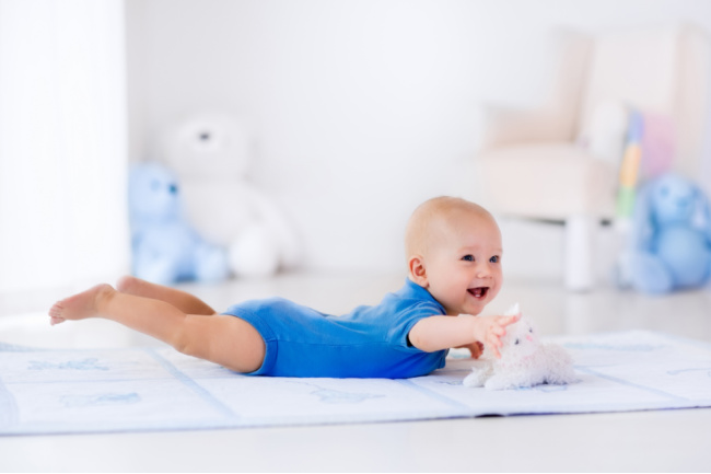 Baby in tummy time in swimming position.