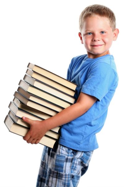 Boy carrying stack of books for heavy work activity at school.